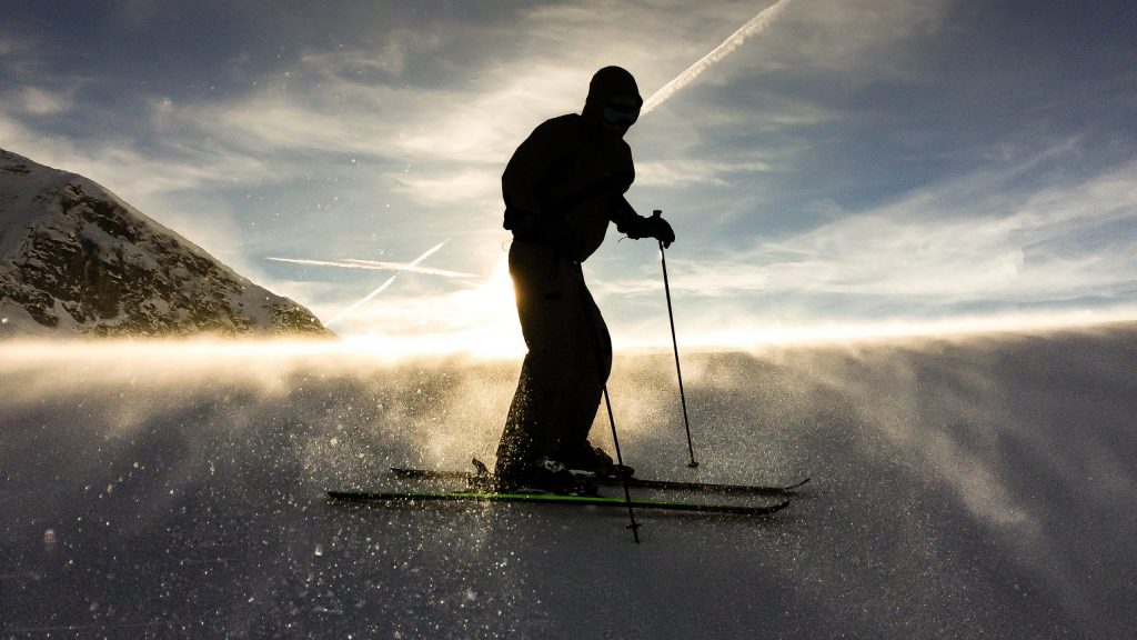 Skieur à contre-jour sur une piste enneigée