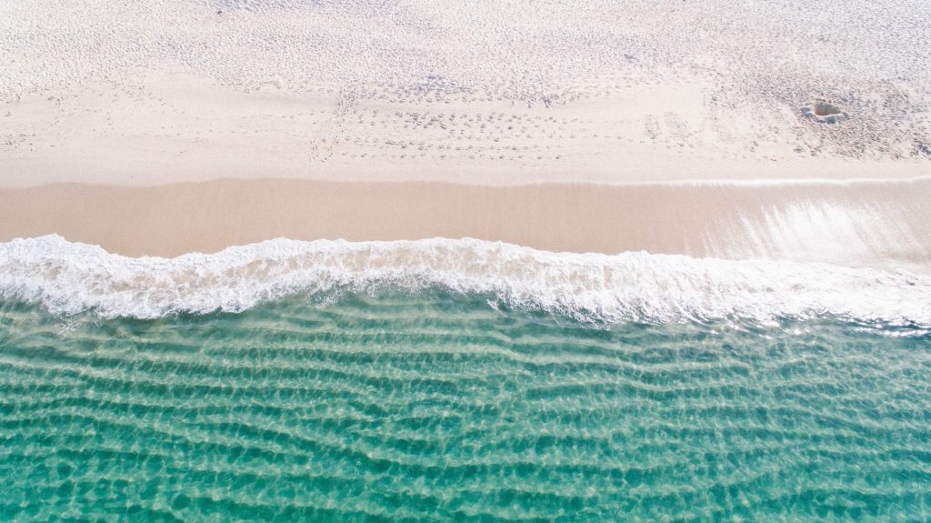 Vue aérienne d'une plage de sable blanc avec eau turquoise