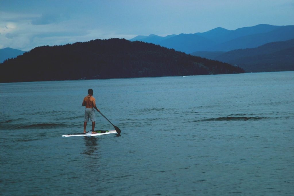 personne faisant du paddle sur un lac de montagne