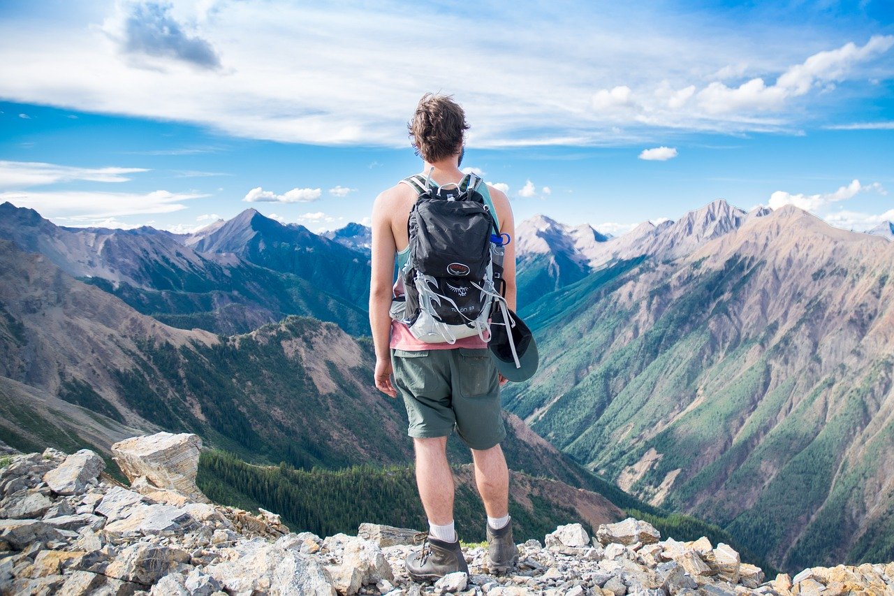 personne se tenant devant un paysage montagnard